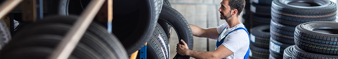 Mechanic selecting a tyre from a huge selection of Tyres Slough